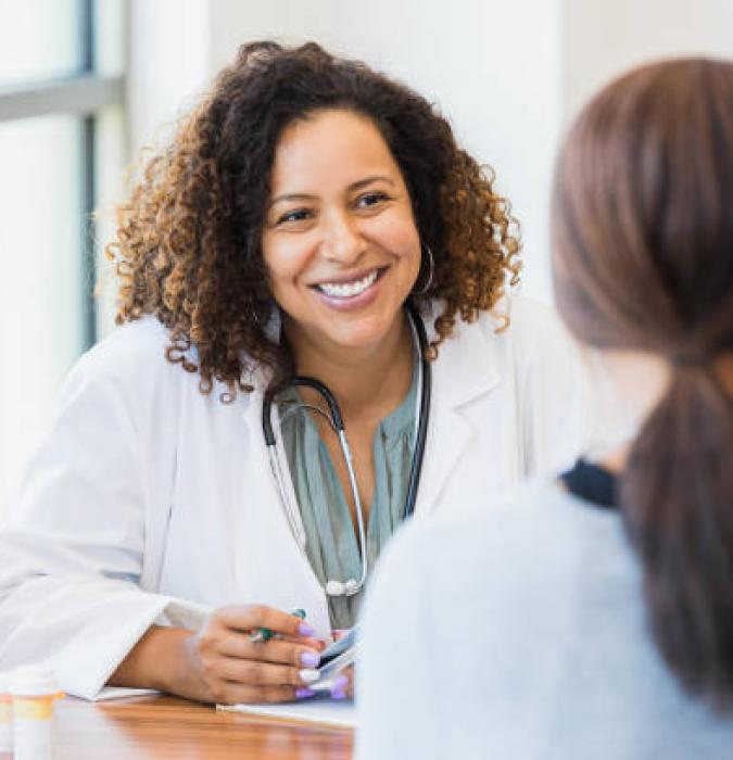Caregiver sitting down talking with a young female patient